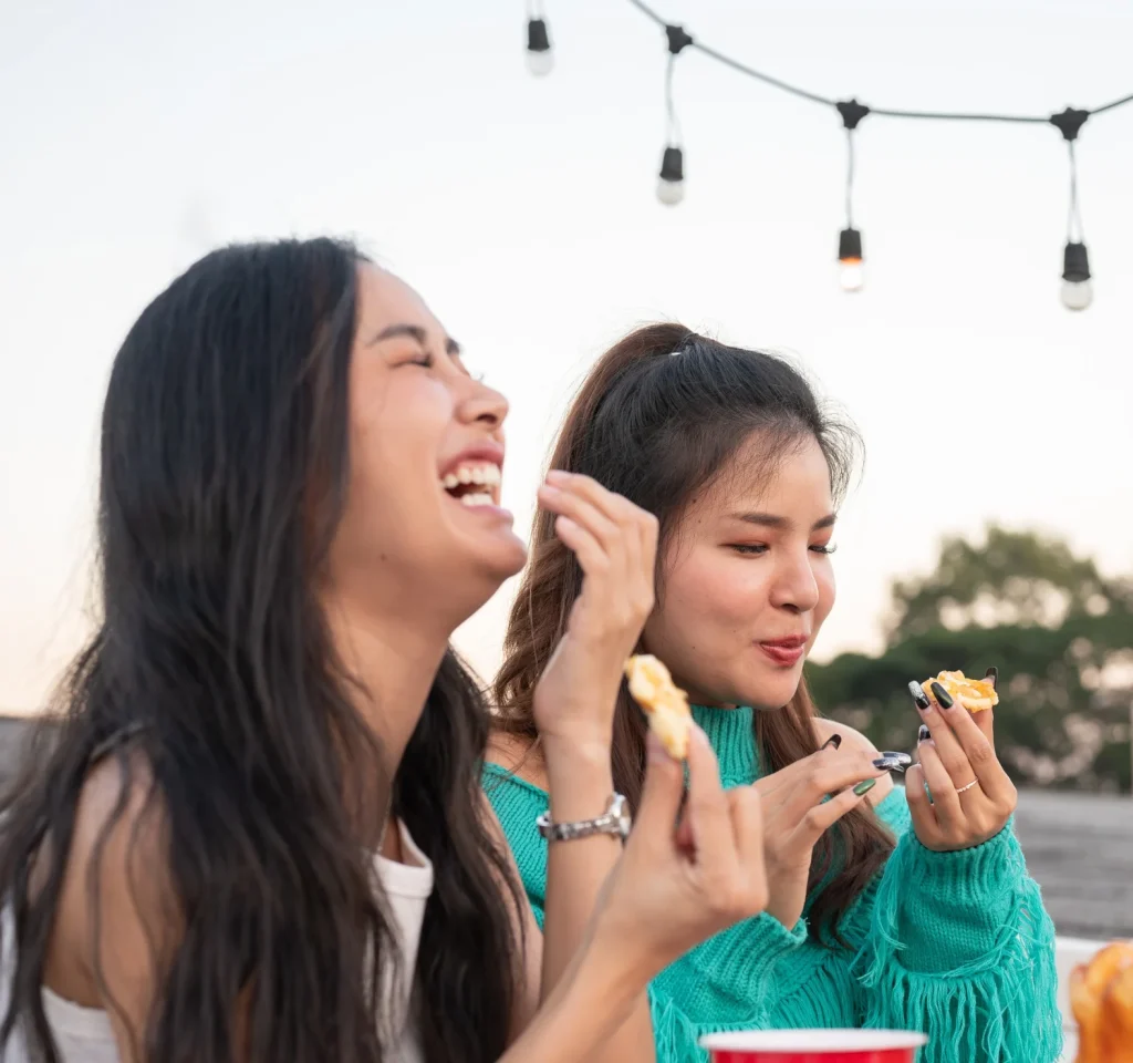 Group Of Cheerful Young Asian Female Friends Laughing Enjoying Talking And Eating